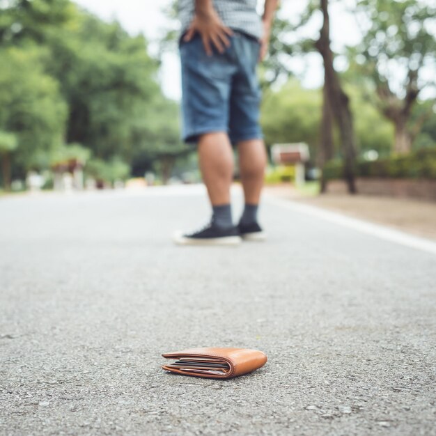 Asian man lose brown wallet on the road in tourist attraction losing wallet concept focus on wallet person