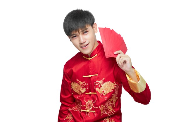 Asian man in mandarin collar dress holding red envelope packet is smiling happily isolated on white background with clipping path. Chinese new year concept.