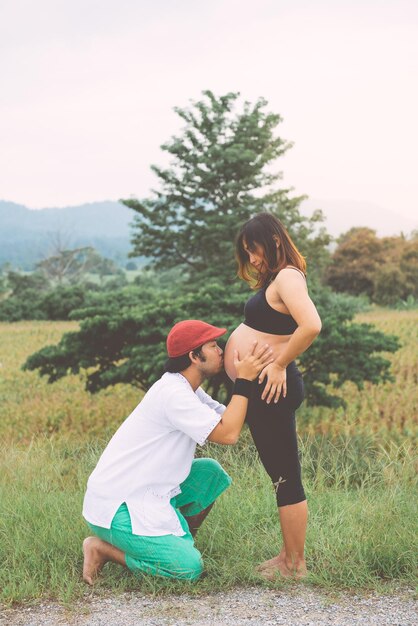 Asian man messy kiss belly of him wise in the fieldcouple concept