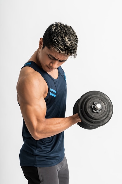 Asian man muscles lift dumbbell weights with energy in the biceps