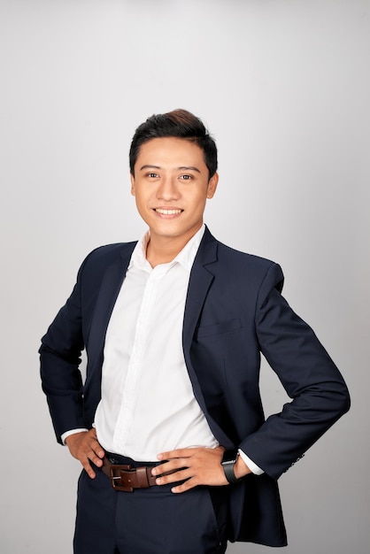 Asian man in office suit posing on white background