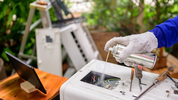 Asian man online learning and repair air conditioner at home. Social distancing and New normal lifestyle.