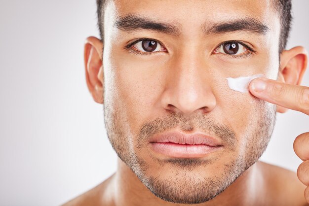 Asian man portrait or face cream for beauty in studio with smile natural cosmetics or glow for shine Dermatology antiaging treatment or model applying skincare lotion or creme on white background