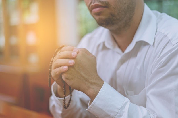 Asian man praying in a Christian church.