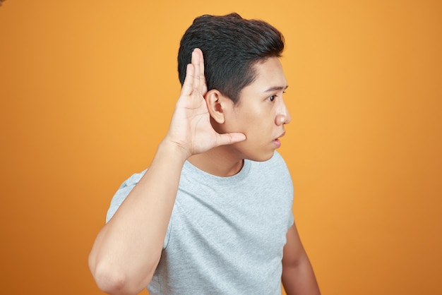 Foto l'uomo asiatico alzò le orecchie all'udito con la mano