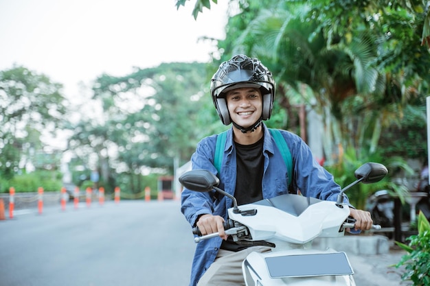 Asian man riding a motorcycle wearing a helmet on the street