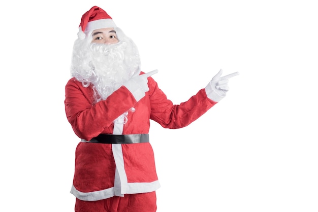 Asian man in Santa costume pointing something isolated over white background. Space for copy space