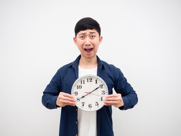 Asian man shocked face hodling clock at ten past eight AM  in his hand late concept on white