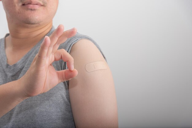 Asian man show symbol ok after being vaccinated