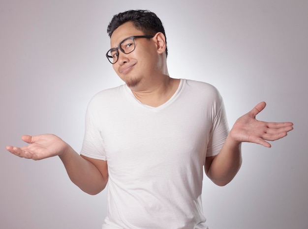 Asian man show unhappy face looking up both palms open shrug shoulder up rejection or denial gesture