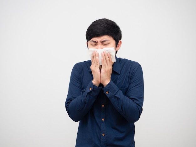 Asian man sick feeling unwell cough and close his face by tissue paper white background