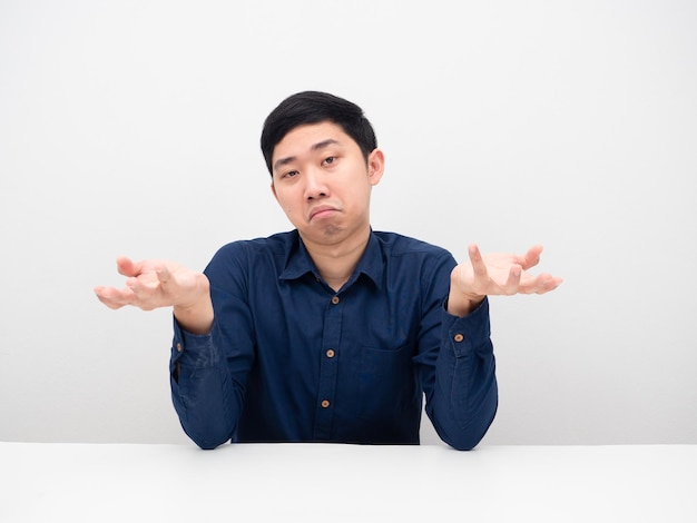 Asian man sitting and feeling doubt gesture up to you