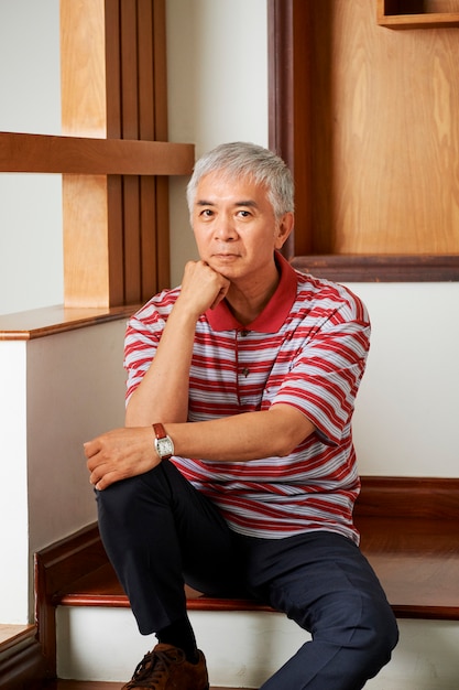 Photo asian man sitting on staircase