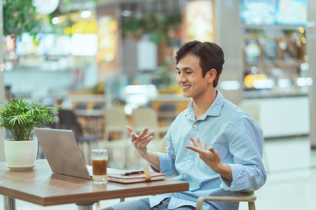 Asian man sitting working alone at a coffee shop