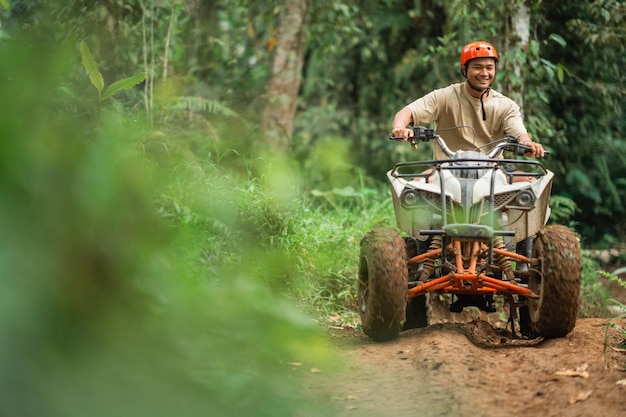 Asian man smiling brightly while riding the atv to spend holidays