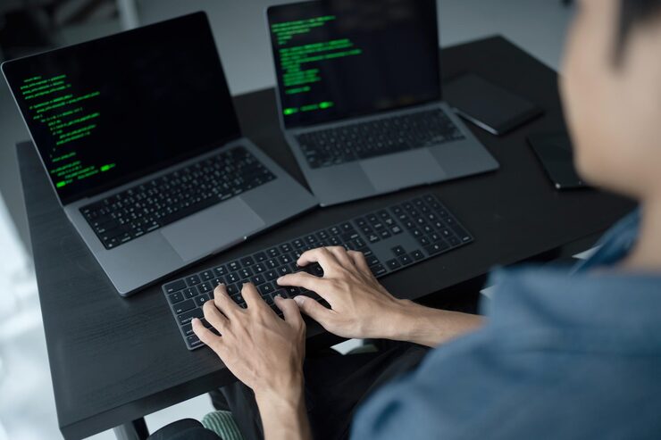 Photo asian man software engineer working on computer at office desk for writing program code it software engineer finding errors tech support devops creating digital