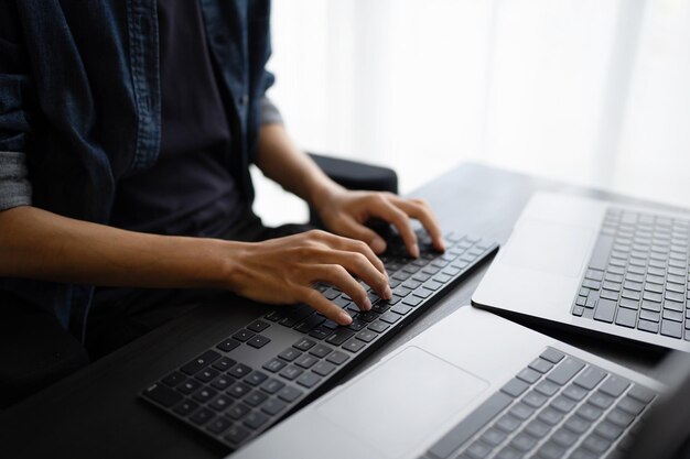 asian man software engineer working on computer at office desk for writing program code it software engineer finding errors tech support devops creating digital