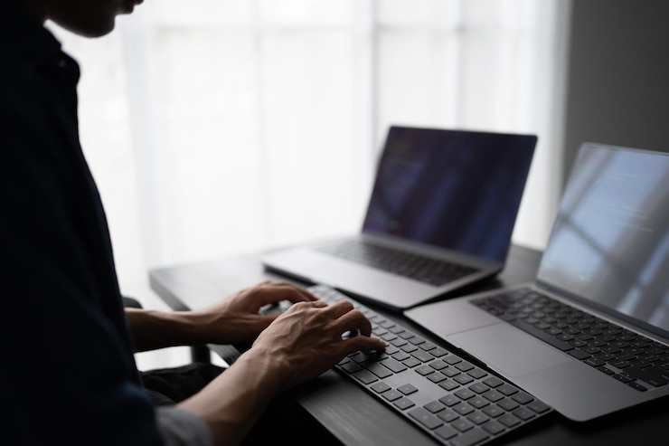 Photo アジア人 ソフトウェアエンジニア プログラミング コードを書くためのオフィスデスクでコンピューターで働く it ソフトウェア エンジニア エラーを発見する テクノロジー サポート デボップス デジタルを作成する
