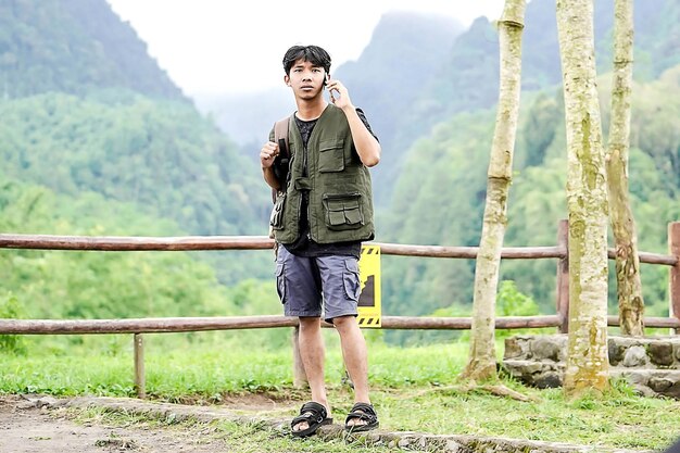 아름 다운 산 자연에서 조끼를 입고 혼자 서 있는 아시아 남자