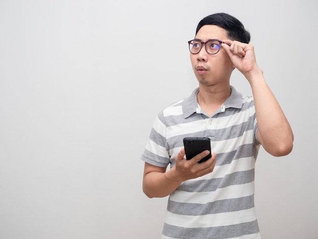 Asian man striped shirt wearing glasses hold smartphone feels excited looking at copy space