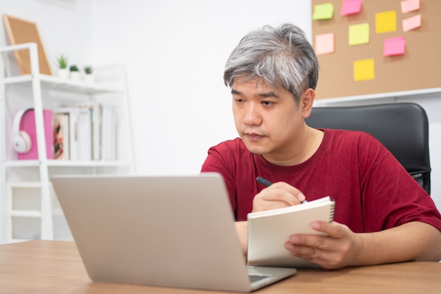 집에서 인터넷에서 새로운 기술을 공부하는 아시아 남자