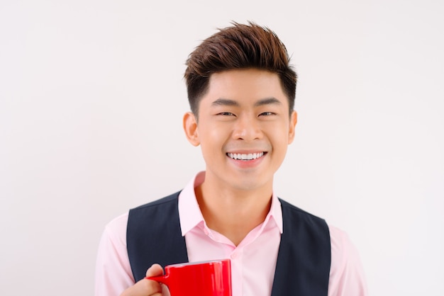 Asian man take a sip of coffee in red cup.