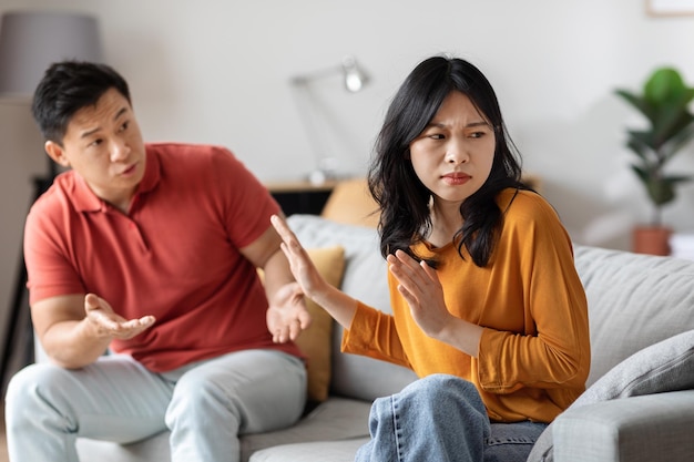 Asian man talking to his irritated wife or girlfriend