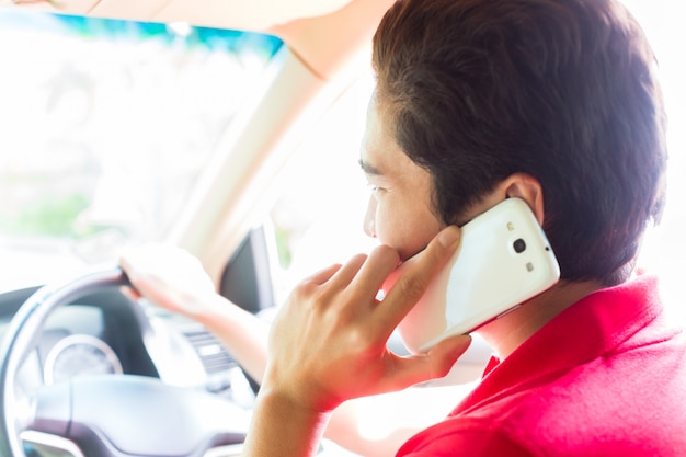 Asian man telephoning while driving car