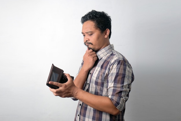 Photo asian man thinking while looking his wallet