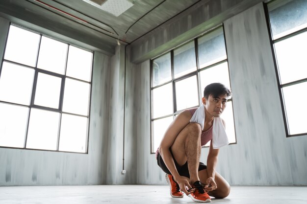 Asian man tie sport shoe laces before exercising