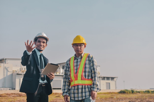 Asian Man two people Business use tablet check on site construction