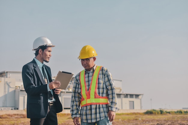 Asian Man two people Business use tablet check on site construction