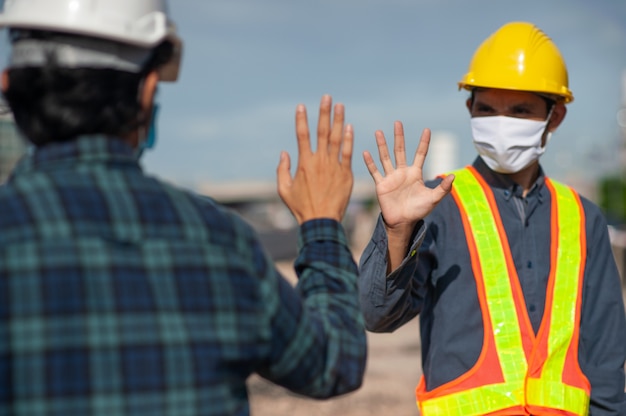 Photo asian man two people engineer shake hand new normal on site construction