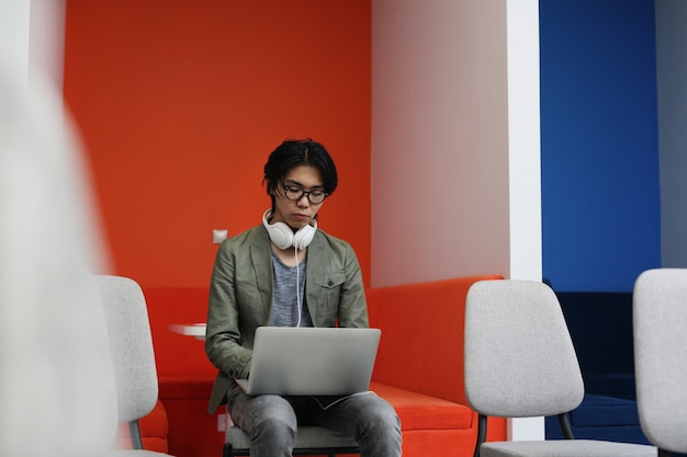 Asian man typing on laptop