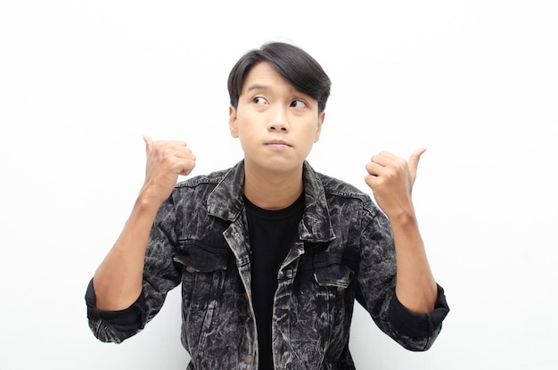 Asian man unsure of what to choose with hand pointing left or right, isolated over white background