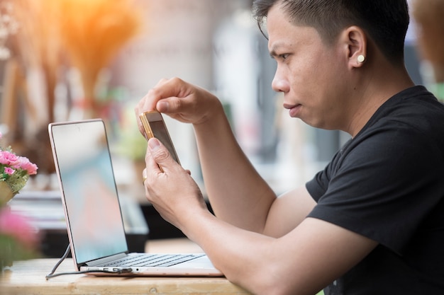 Asian man use computer laptop in coffee shop 