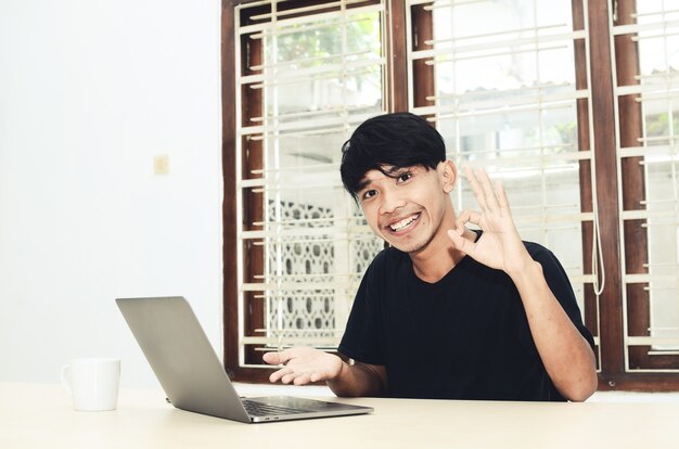 L'uomo asiatico era seduto indicando il laptop