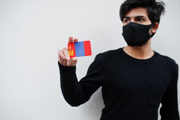 Asian man wear all black with face mask hold Mongolia flag in hand isolated on white background Coronavirus country concept