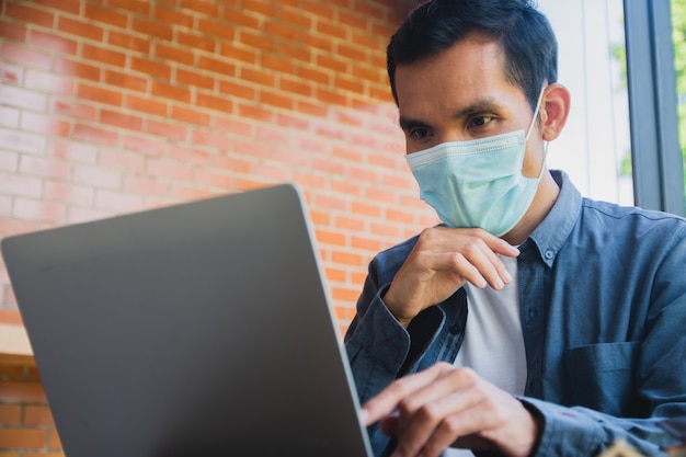 Asian man wear face mask working computer at home, Trading online at home