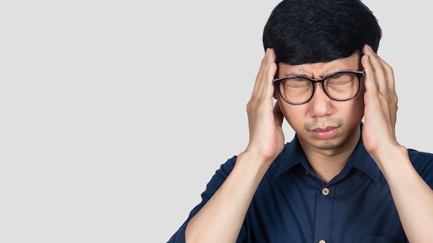 アジア人男性はメガネをかけて片頭痛で頭痛を感じる