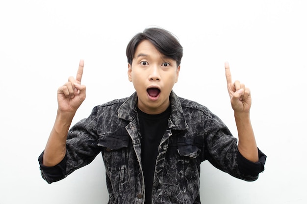 asian man wear jacket jeans pointing finger to copy space presenting and showing goods.