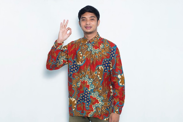 asian man wearing batik with ok sign gesture tumb up isolated on white background