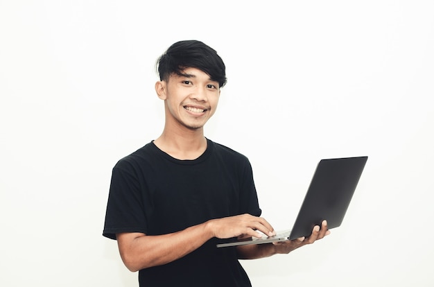 Uomo asiatico che indossa una camicia nera casual, portando un laptop con un'espressione sorridente