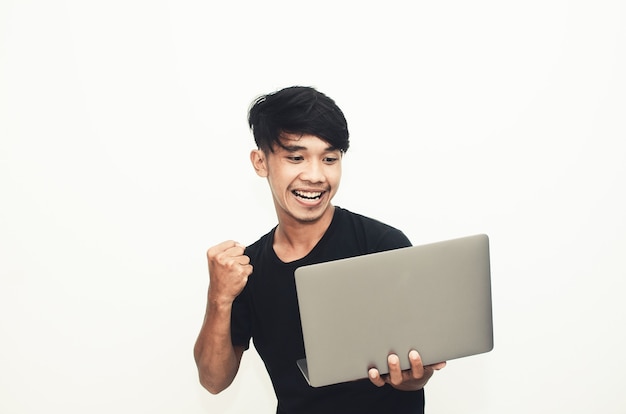 An Asian man wearing a casual black T-shirt carries a laptop with the expression of finding ideas