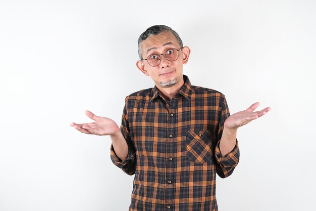 Foto uomo asiatico che indossa abiti casual all'oscuro e confuso con le braccia aperte senza idea e faccia dubbiosa