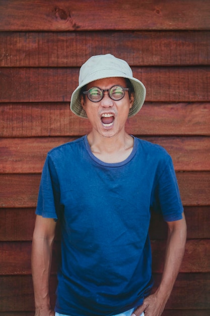 Asian man wearing clothes hat acting wow with funny face