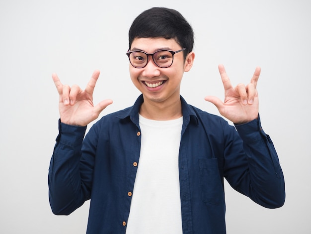 L'uomo asiatico con gli occhiali sorride al viso mostra la mano amore ritratto sfondo bianco