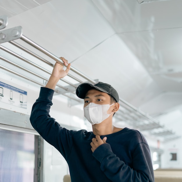 Asian man wearing a mask in train