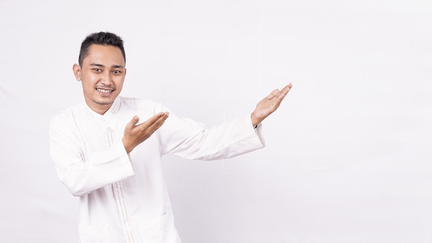 Asian man wearing moslem clothes pointing blank screen  isolated white space