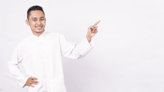 Asian man wearing moslem clothes pointing blank screen  isolated white space